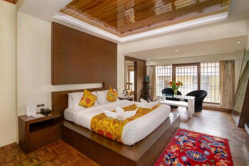 a large bedroom with a large bed and a desk at Muscatel Yavachi - 400 Mts from MG Marg in Gangtok