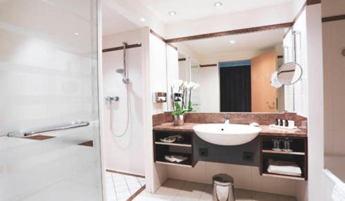ein Bad mit einem Waschbecken und einer Dusche in der Unterkunft SCHLOSS Fleesensee in Göhren-Lebbin