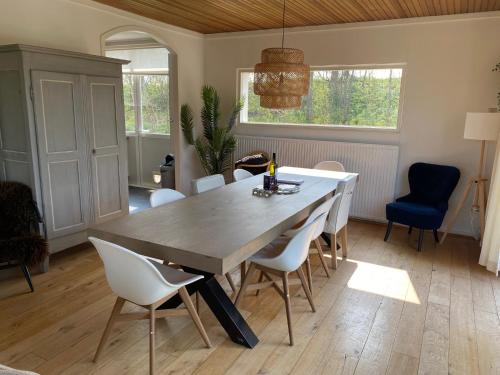 a dining room with a large wooden table and chairs at Family bungalow with garden for 6-8 people in Cadzand