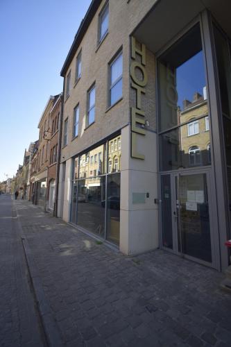 a building with a sign on the side of a street at Hotel O Ieper in Ypres