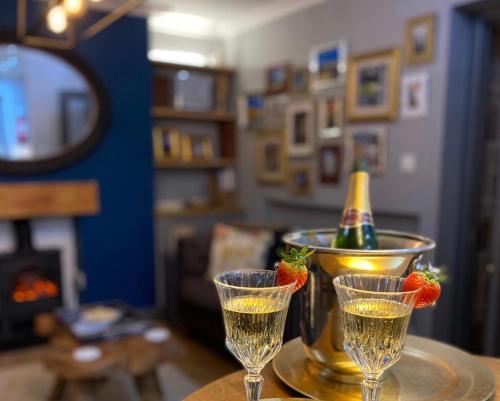 two glasses of champagne and a bowl with strawberries in it at OurHaus in Beverley