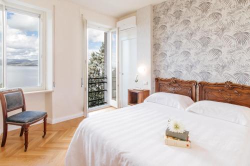 a bedroom with a bed with a white bedspread and a window at Hotel Aganoor in Castiglione del Lago