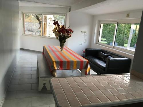 un salon avec un vase de fleurs sur une table dans l'établissement Appartement Rez de chaussé, à Bollène