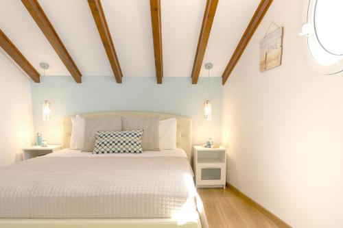 a bedroom with a white bed and wooden ceilings at Villa Renata & Villa Filippos with private Plunge Pool by Konnect in Agios Gordios