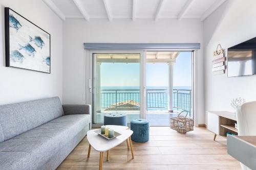 a living room with a couch and a view of the ocean at Villa Renata & Villa Filippos with private Plunge Pool by Konnect in Agios Gordios