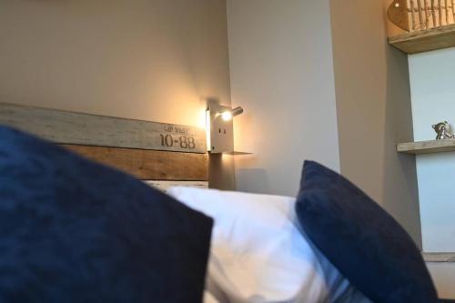 a bedroom with a bed with blue pillows at L'Arche de Porquerolles in Porquerolles