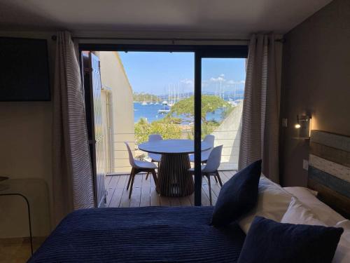 a bedroom with a bed and a table and a balcony at L'Arche de Porquerolles in Porquerolles