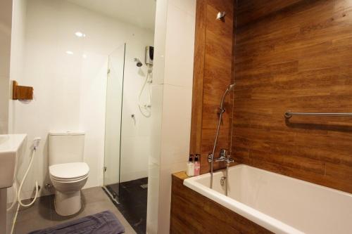 uma casa de banho com uma banheira, um WC e um chuveiro em NARITA Amata - SHA Plus Certified em Chon Buri