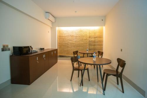 Una cocina y un comedor con mesa y sillas. en Jatra Flagship Sylhet City Centre, en Sylhet