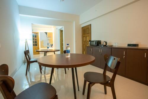 a kitchen with a table and chairs in a room at Jatra Flagship Sylhet City Centre in Sylhet