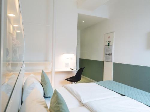 a hospital room with a bed and a chair at bedpark Stellingen in Hamburg