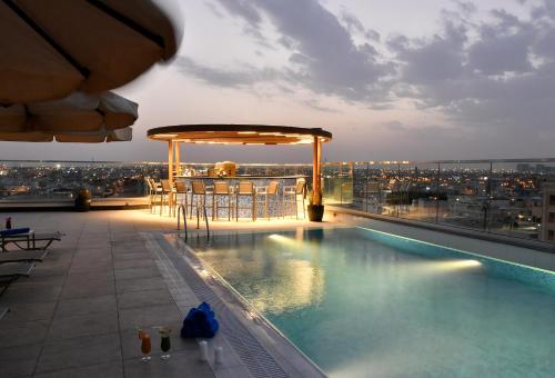 a swimming pool on the roof of a building at Golden Tulip Riyadh Convention and Exhibition Center in Riyadh