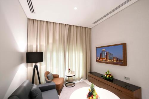 a living room with a couch and a tv at Golden Tulip Riyadh Convention and Exhibition Center in Riyadh