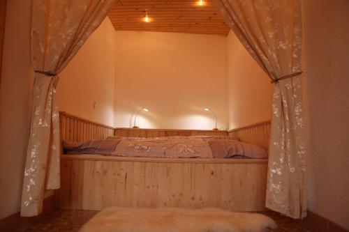 アルトシュテッテンにあるFerienwohnung im Grünenのカーテン付きのベッドルーム1室(ベッド1台付)