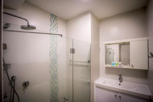 a bathroom with a shower and a sink at Acco Beach Hotel in ‘Akko