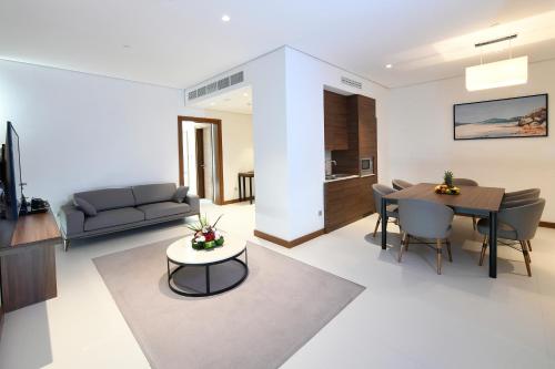 a living room with a table and a dining room at Golden Tulip Riyadh Convention and Exhibition Center in Riyadh