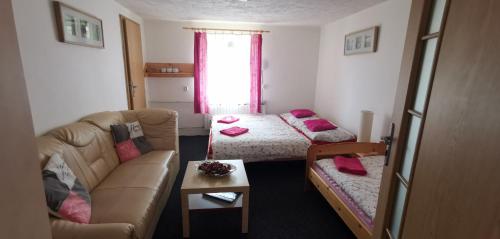 a living room with a couch and a bed at Penzion Tomy Pihlov in Horní Planá