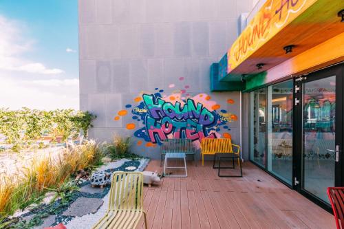 a patio with chairs and a wall with graffiti at Hound Hotel Busan Station in Busan