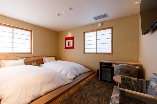 Säng eller sängar i ett rum på ひがし茶屋街らしく金沢 Hotel Rashiku kanazawa
