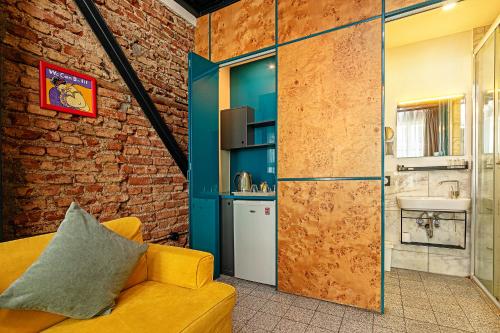 a living room with a yellow couch and a brick wall at Raven Suites Taksim in Istanbul