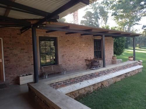 an outdoor patio with a bench and a table at Old Balgowan Farm Cottage in Balgowan
