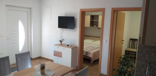 奧利布島的住宿－Apartmani Petra，一间带一张床和一张桌子的房间和一间带镜子的房间
