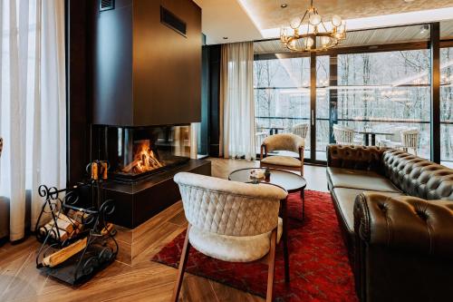 a living room with a couch and a fireplace at Brezovica Hotel & SPA in Brezovicë