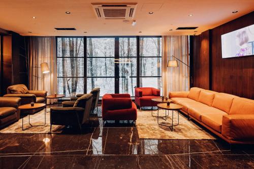a lobby with couches and chairs and a large window at Brezovica Hotel & SPA in Brezovicë