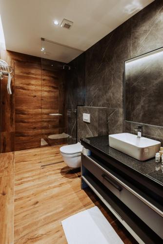 a bathroom with a sink and a toilet in it at Brezovica Hotel & SPA in Brezovicë