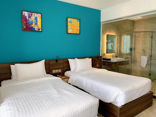 two beds in a room with a blue wall at CHAU KHUONG HOTEL in Long Xuyên