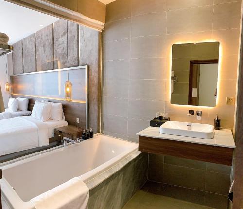 a bathroom with a tub and a bed and a sink at CHAU KHUONG HOTEL in Long Xuyên