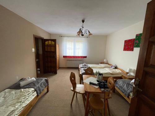a room with two beds and a table in it at Willa Karolina in Czorsztyn