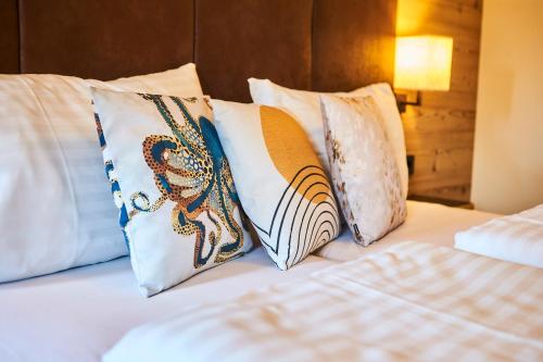a group of pillows sitting on top of a bed at Fuchs und Gretl in Saalbach Hinterglemm