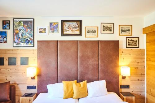a hotel room with a bed with a wooden headboard at Fuchs und Gretl in Saalbach Hinterglemm
