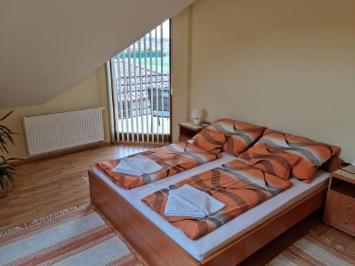 ein Schlafzimmer mit einem Bett in einem Zimmer mit einem Fenster in der Unterkunft Mónika apartman in Bük