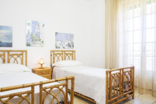 a bedroom with two beds and a window at Villetta Lungomare Gallipoli - Family House in Marina di Mancaversa
