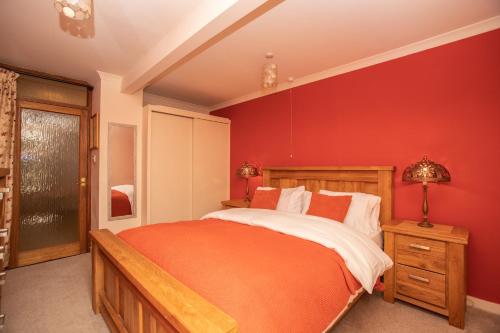 a bedroom with a red accent wall and a bed at Aftonbank in Pitlochry
