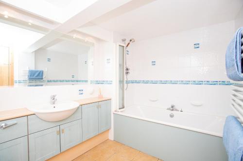 Baño blanco con bañera y lavamanos en Aftonbank en Pitlochry