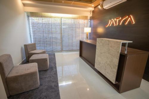 a lobby with two chairs and a reception desk at Jatra Flagship Khulna City Centre in Khulna