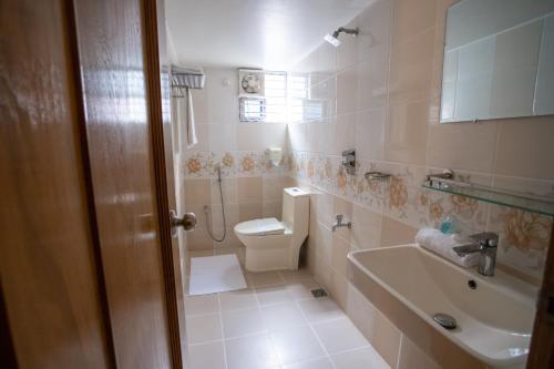 a bathroom with a toilet and a sink at Jatra Flagship Khulna City Centre in Khulna