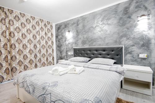a bedroom with a bed with white sheets and a wall at Cazare Moldi Btt in Câmpulung Moldovenesc
