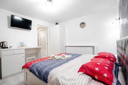 a bedroom with a bed with red and white pillows at Cazare Moldi Btt in Câmpulung Moldovenesc