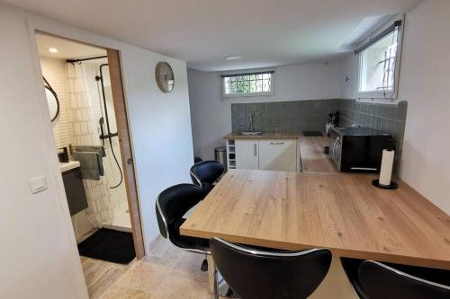une cuisine avec une grande table en bois et des chaises noires dans l'établissement La Casita, à Saint-Étienne-du-Grès