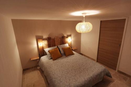1 dormitorio con cama y lámpara de araña en La Casita, en Saint-Étienne-du-Grès