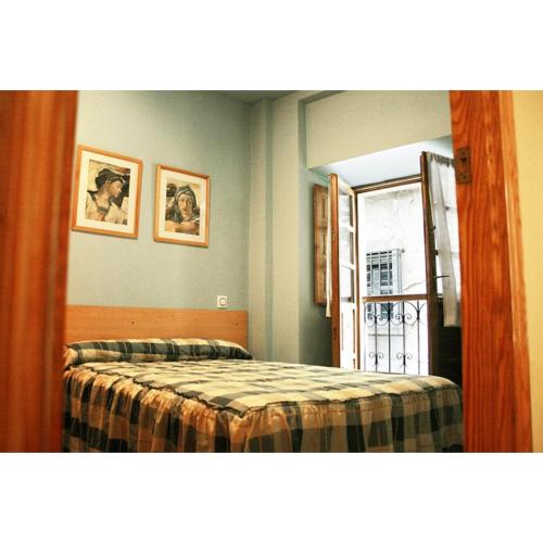 a bedroom with a bed and a window and a mirror at La Refierta in Cangas del Narcea