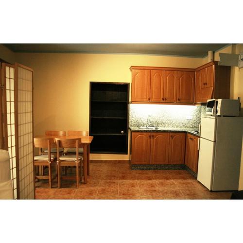 a kitchen with a table and a white refrigerator at La Refierta in Cangas del Narcea