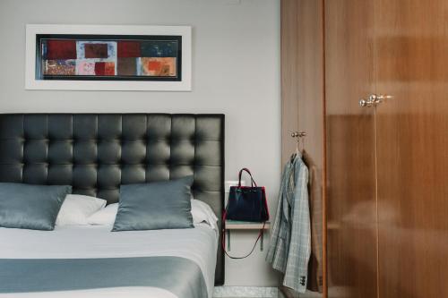 a bedroom with a bed with a black headboard at Citizentral Gascons in Valencia