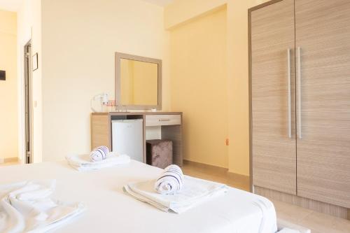 two beds in a room with a mirror at Hotel Mesun Himare in Himare
