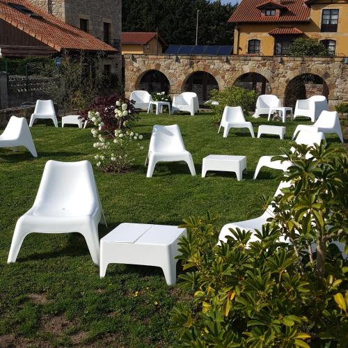a group of white chairs sitting on the grass at Posada la Leyenda in Santillana del Mar