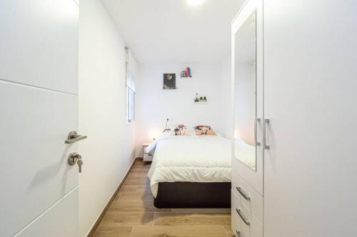 a small white bedroom with a bed and a closet at The rest between Picasso & Pompidou in Málaga
